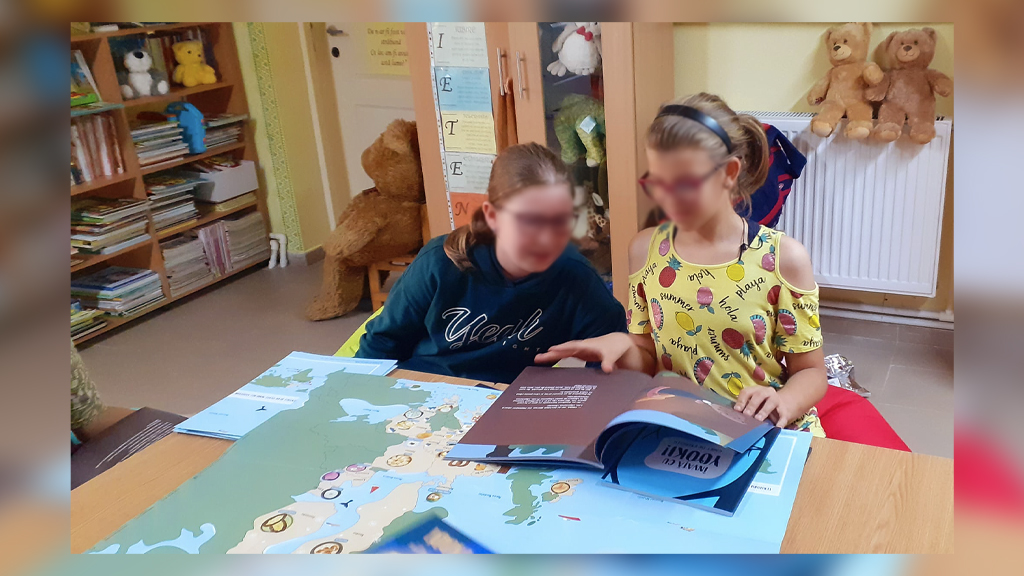 Две момичета четат книжката за приключенията на Юки