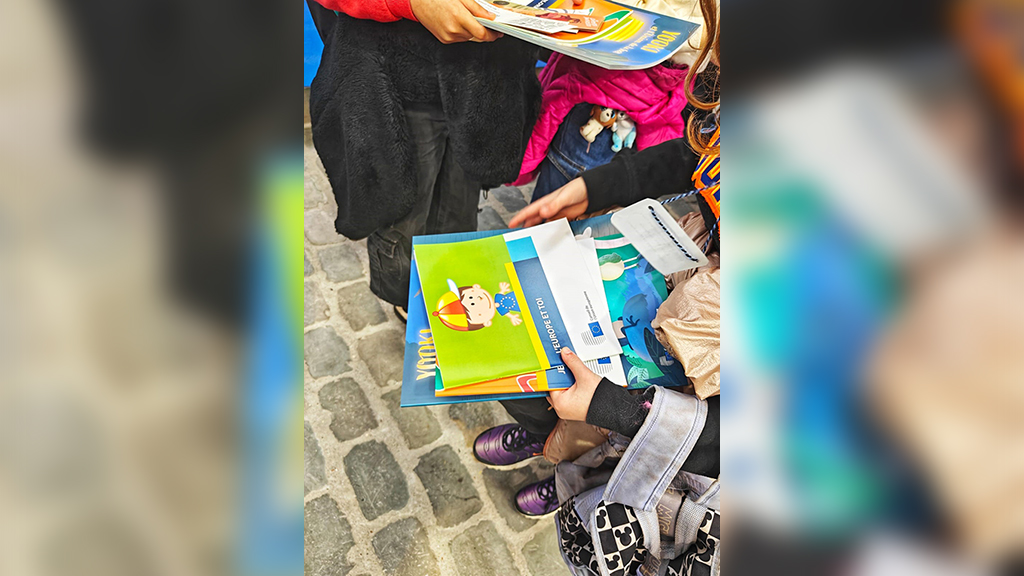 Деца държат образователни материали за ЕС на Панаира на книгата в Брюксел, 2024 г.