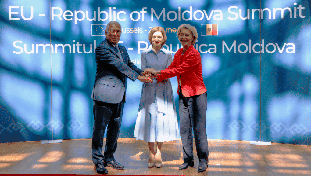 Le président Costa et les présidentes Sandu et von der Leyen sont debout sur une scène, les mains jointes au centre en signe d'unité, devant un arrière-plan bleu où il est écrit "Sommet UE-République de Moldavie".